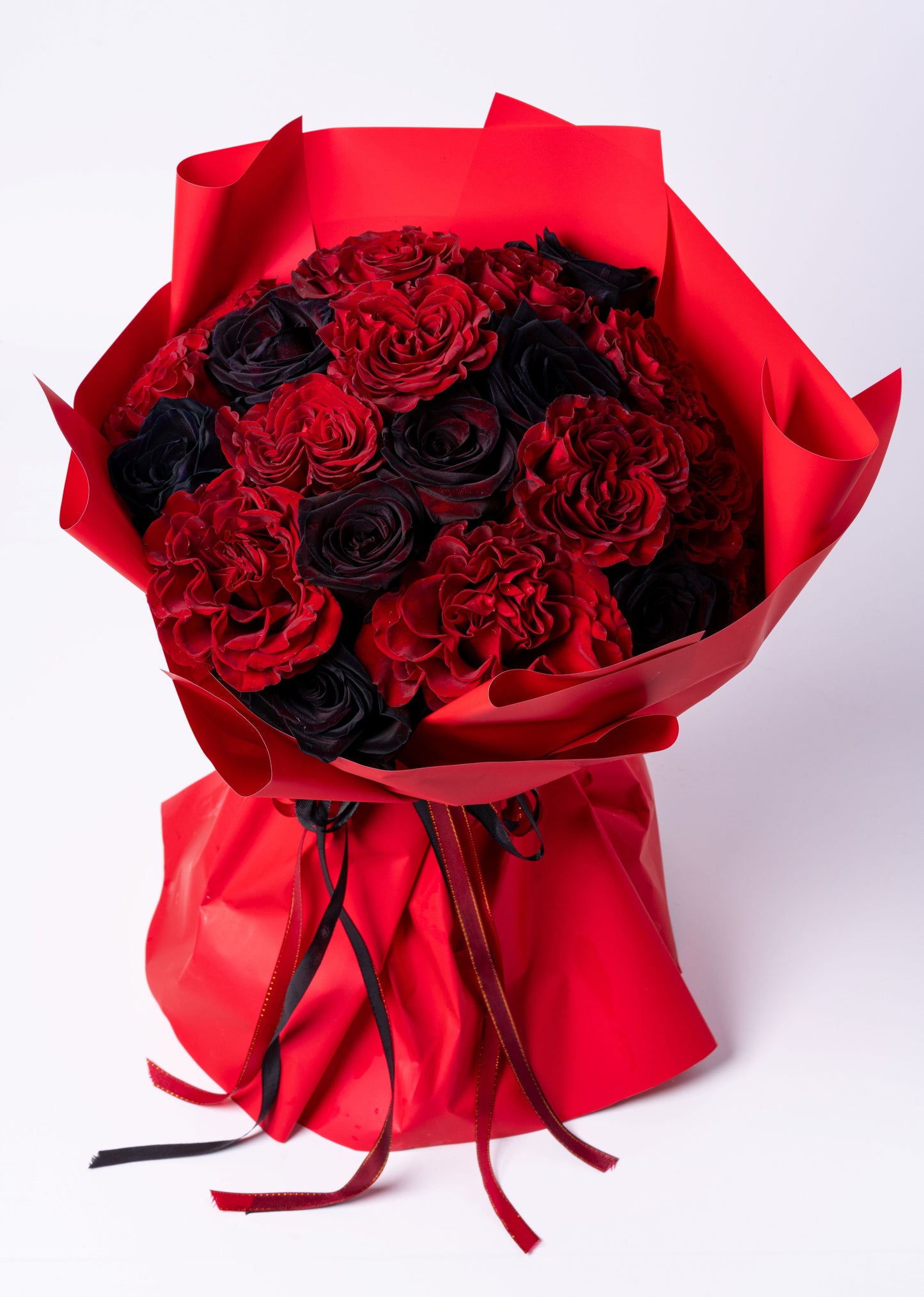 Luxury wrapped bouquet of red and black roses with deep red carnations. Dramatic, romantic, and modern. Vase not included. Same-day Toronto delivery