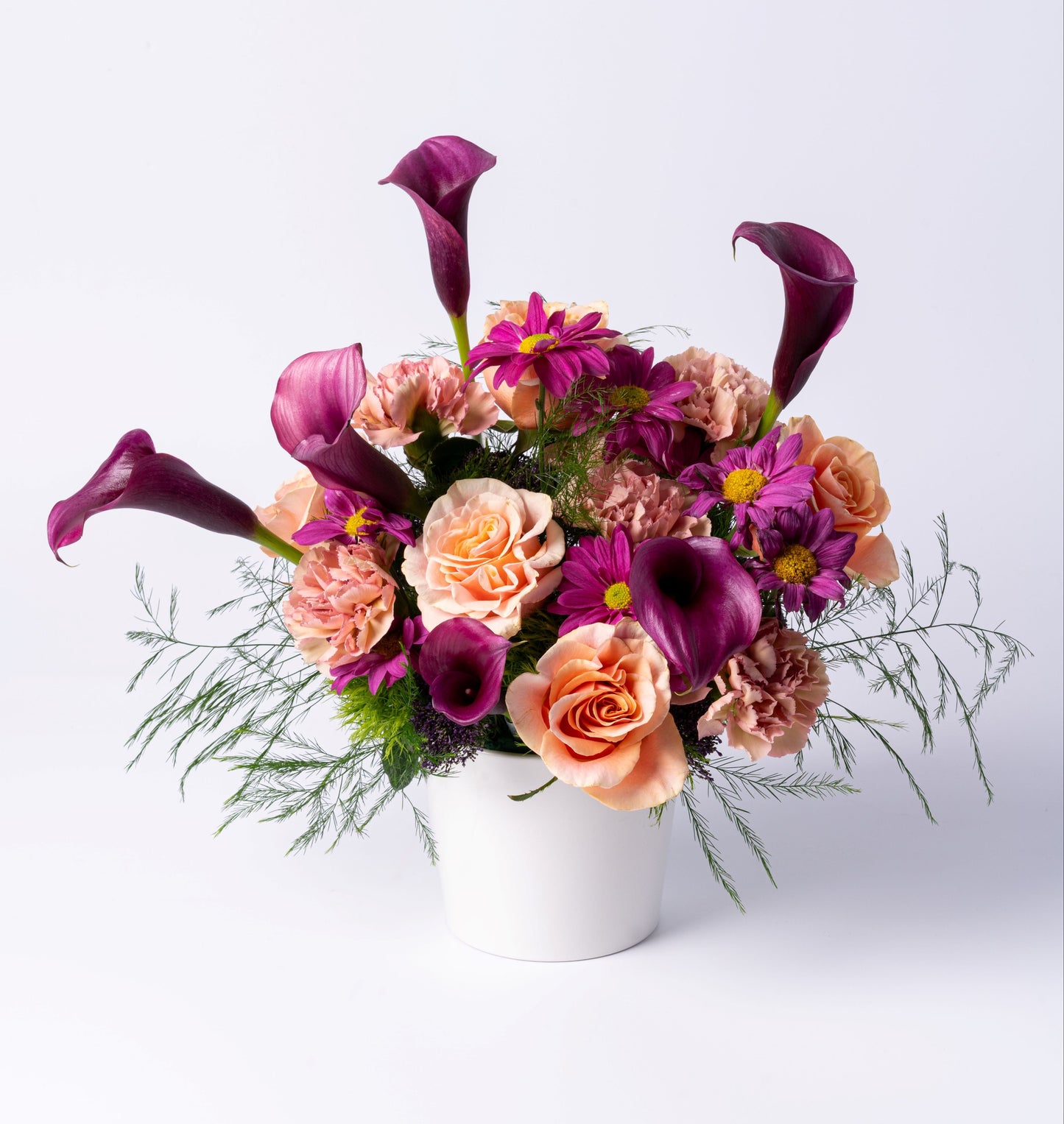 Modern vase arrangement with plum calla lilies, peach roses, and mauve blooms. A bold, romantic gift. Same-day flower delivery in Toronto