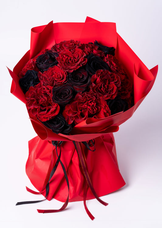 Luxury wrapped bouquet of red and black roses with deep red carnations. Dramatic, romantic, and modern. Vase not included. Same-day Toronto delivery