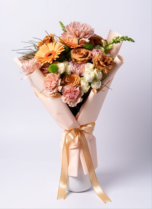 Elegant wrapped bouquet with peach gerberas, toffee roses, carnations, and spray roses. Vase not included. Same-day Toronto flower delivery