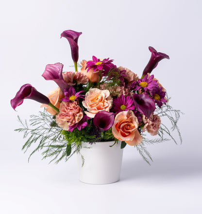 Modern vase arrangement with plum calla lilies, peach roses, and mauve blooms. A bold, romantic gift. Same-day flower delivery in Toronto