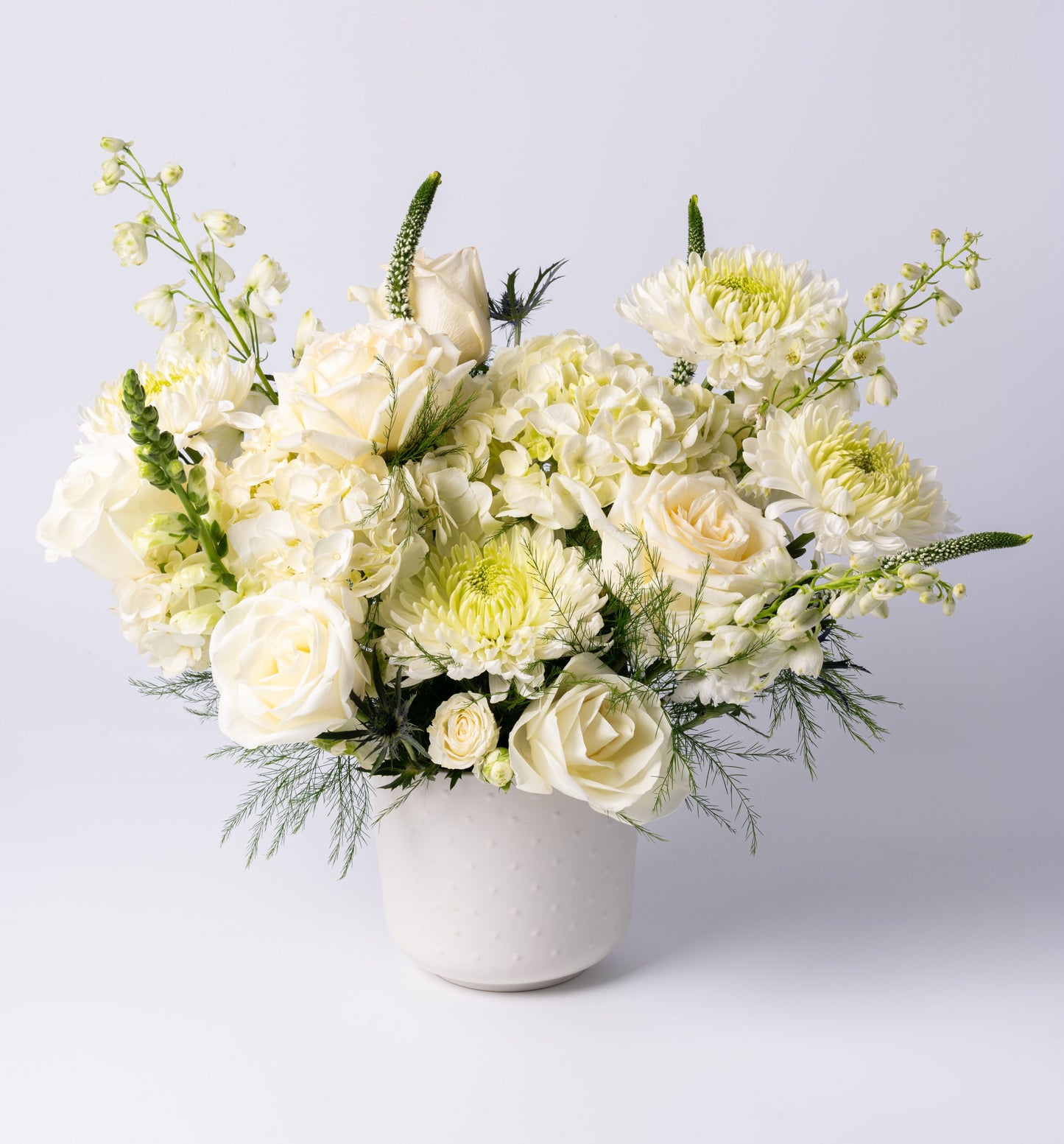 White vase arrangement with roses, hydrangea, chrysanthemums, and snapdragons in a modern ceramic pot – Rainbow Floral Toronto