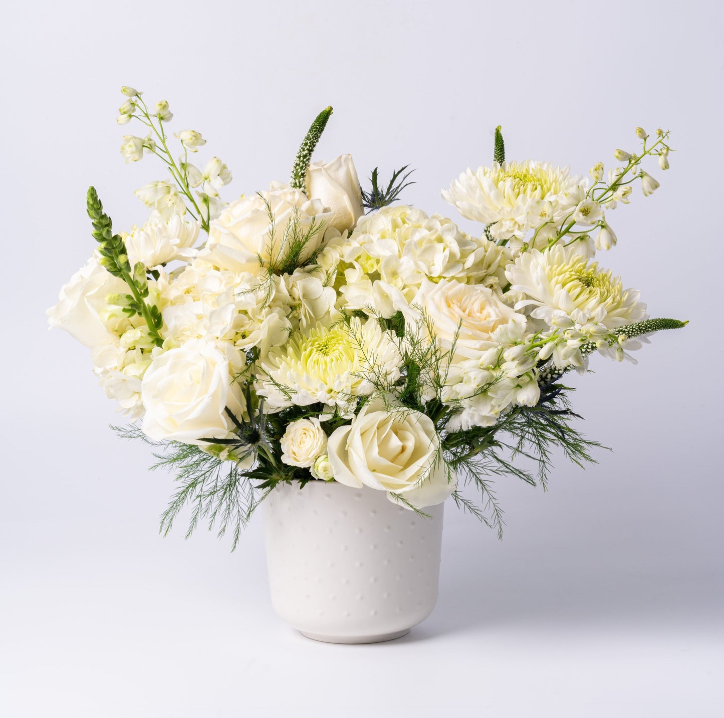White vase arrangement with roses, hydrangea, chrysanthemums, and snapdragons in a modern ceramic pot – Rainbow Floral Toronto