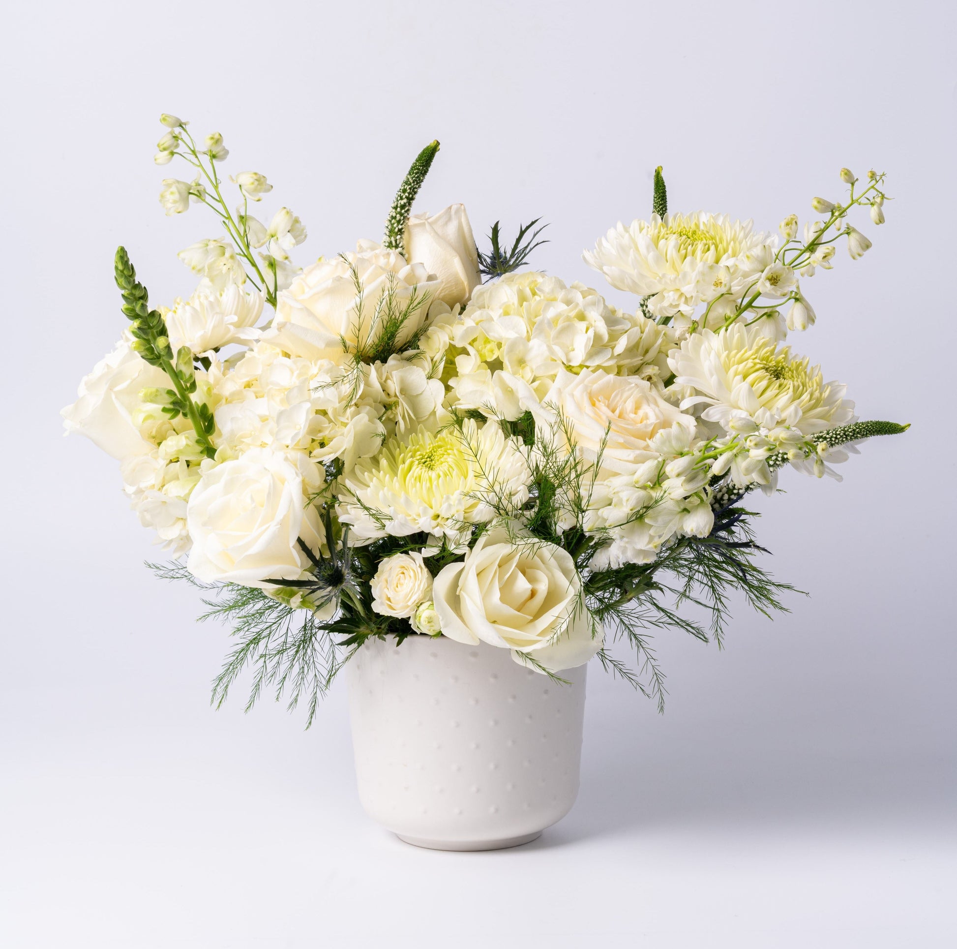 White vase arrangement with roses, hydrangea, chrysanthemums, and snapdragons in a modern ceramic pot – Rainbow Floral Toronto
